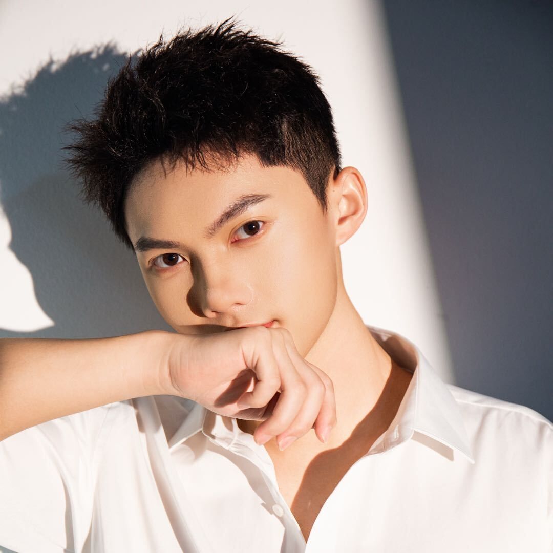 Levy Lyu in a white shirt, resting his chin on his hand